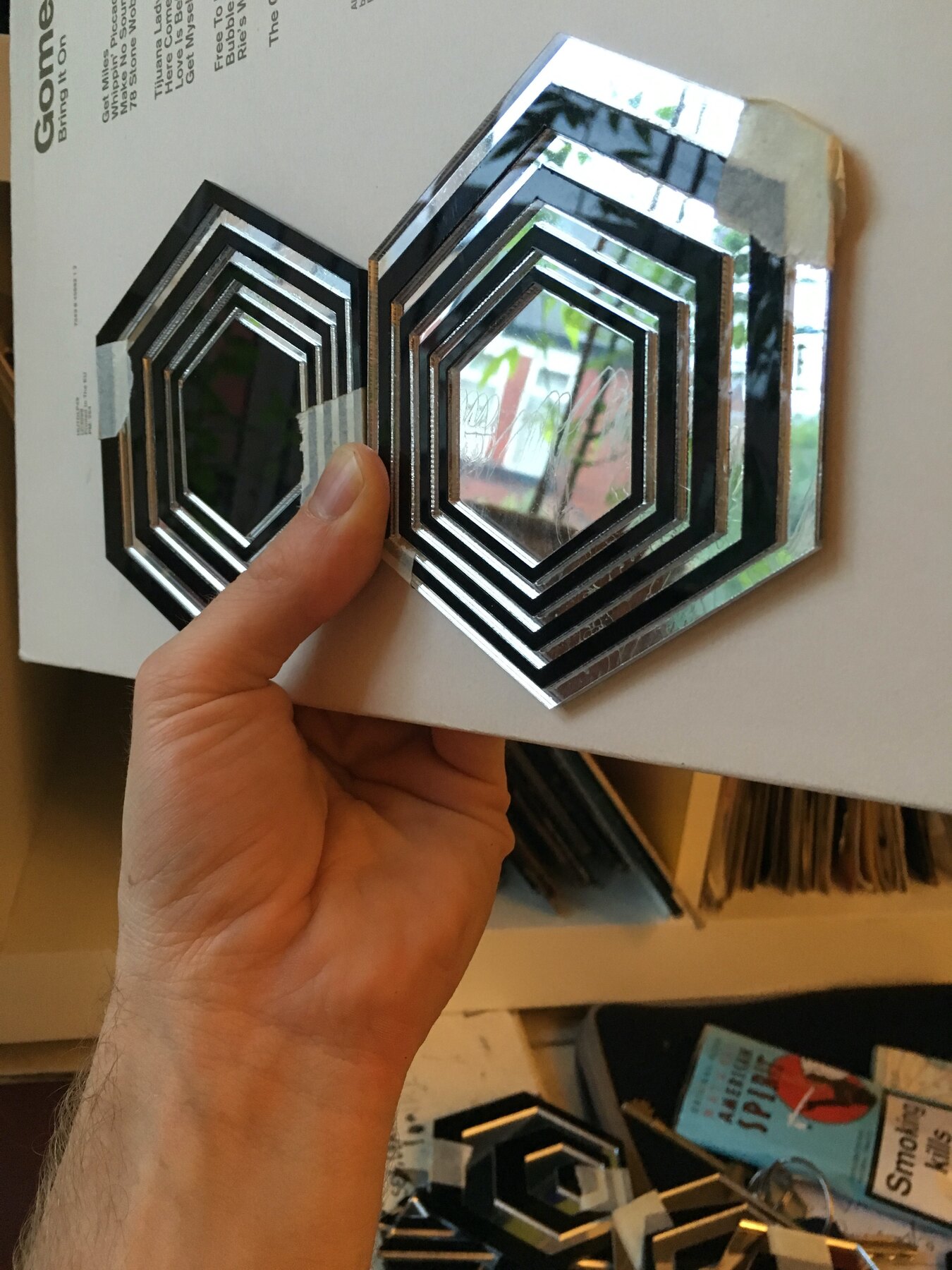Layered laser-cut hexagon tests in mirrored and black perspex