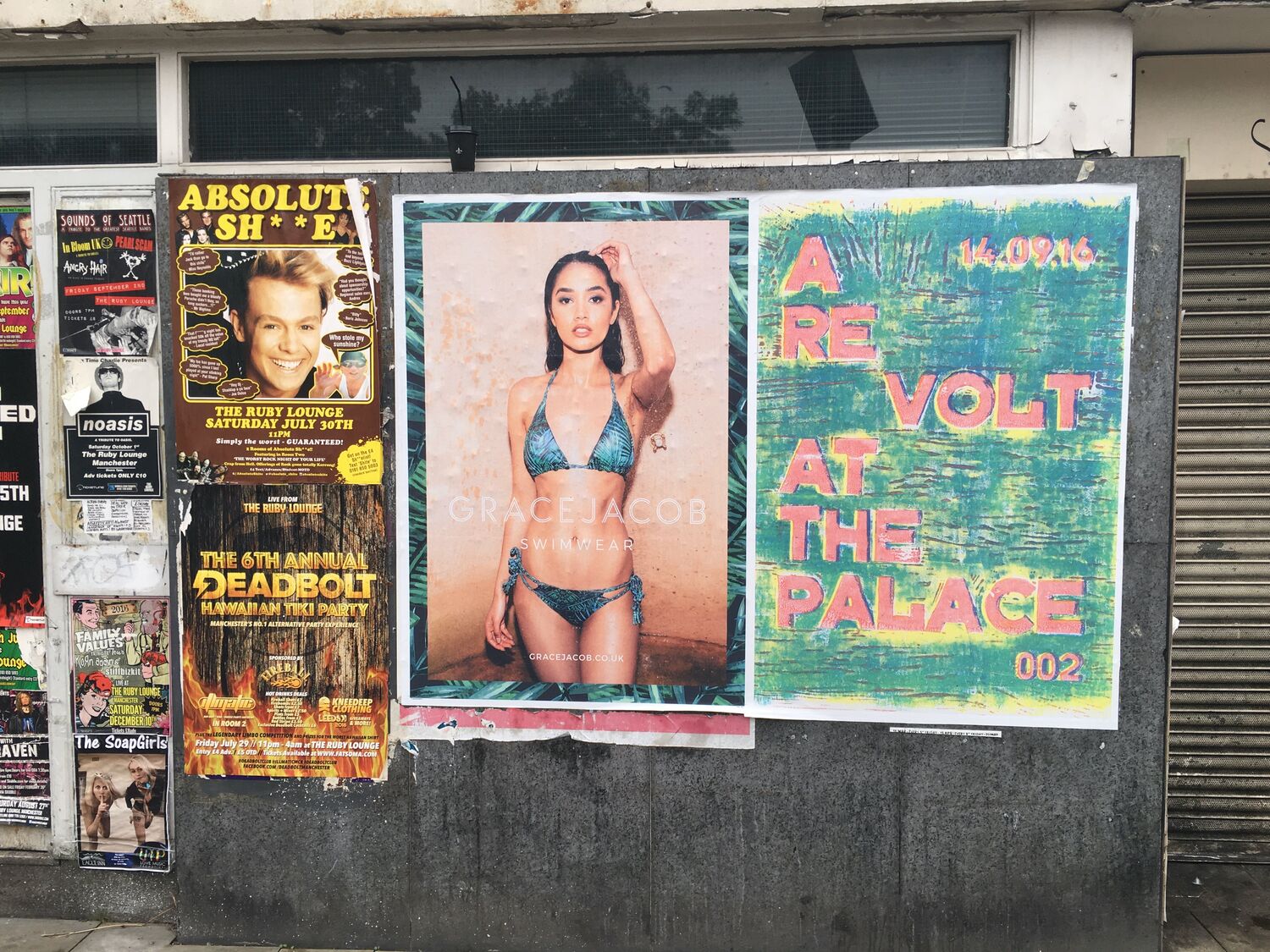A Revolt at the Palace poster among fly-posters on a street hoarding