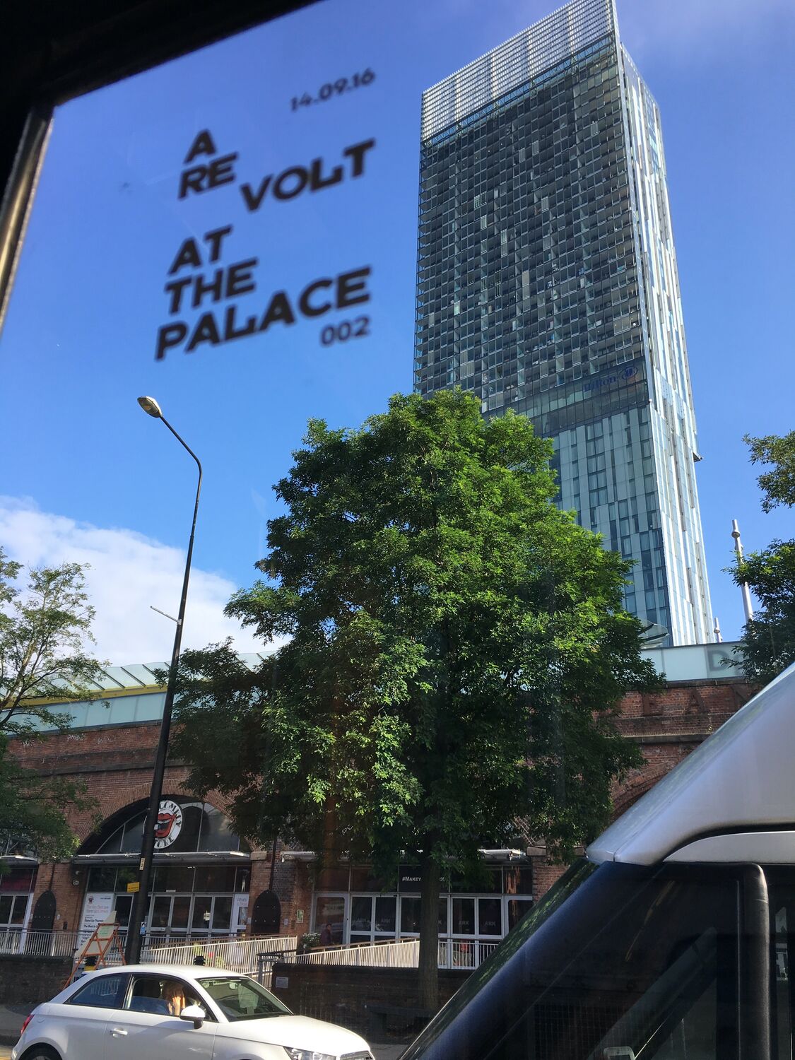 A Revolt at the Palace projected against the Manchester skyline