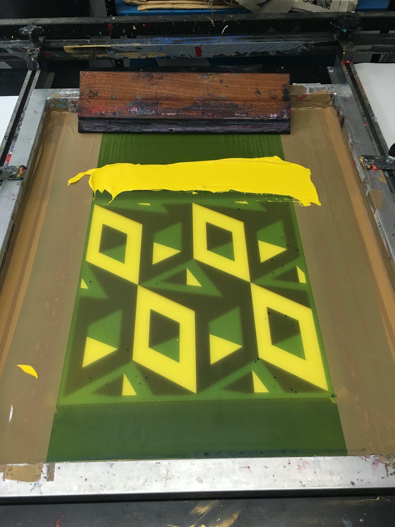 Screen printing the Refuge wallpaper, squeegee mid-pull on the press at one69A