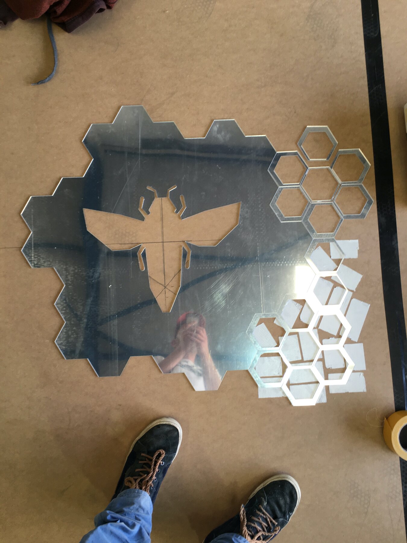 The Manchester worker bee in mirrored perspex, ringed by honeycomb hexagons