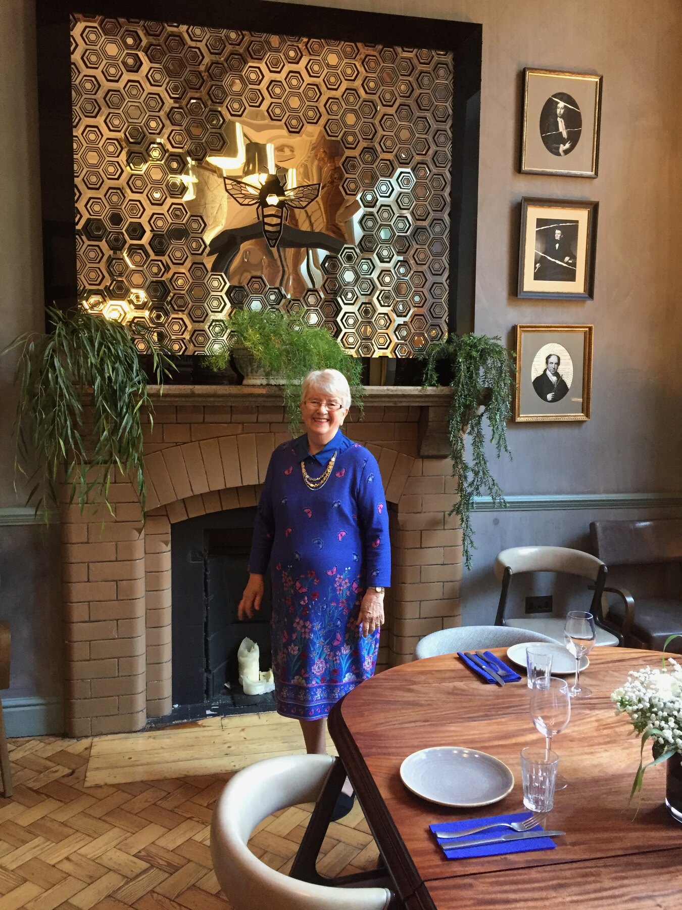 Mark's grandmother beside the finished mirror installation in the Refuge dining room, Manchester