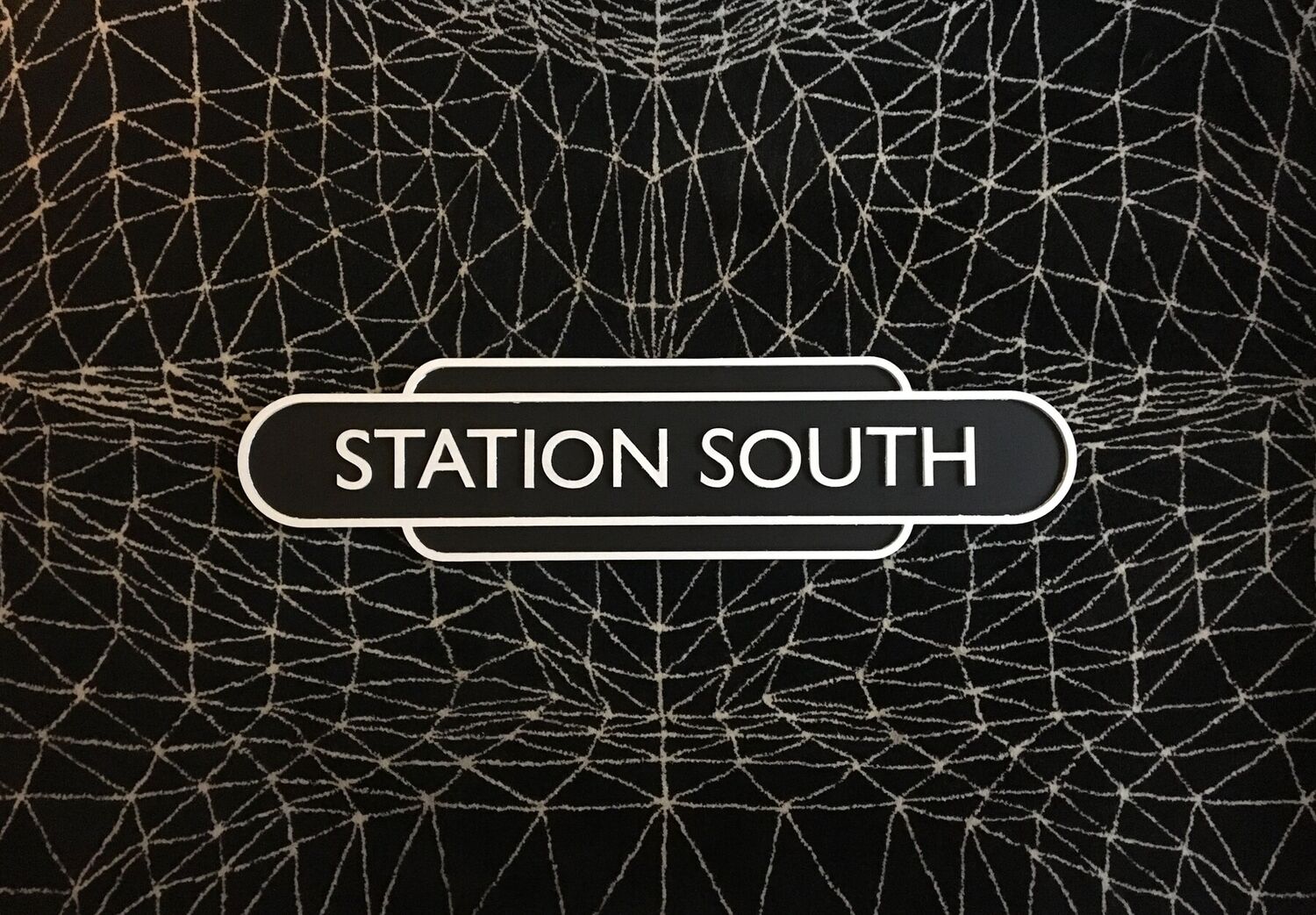 The first Station South nameboard set on a rug by Lazerian