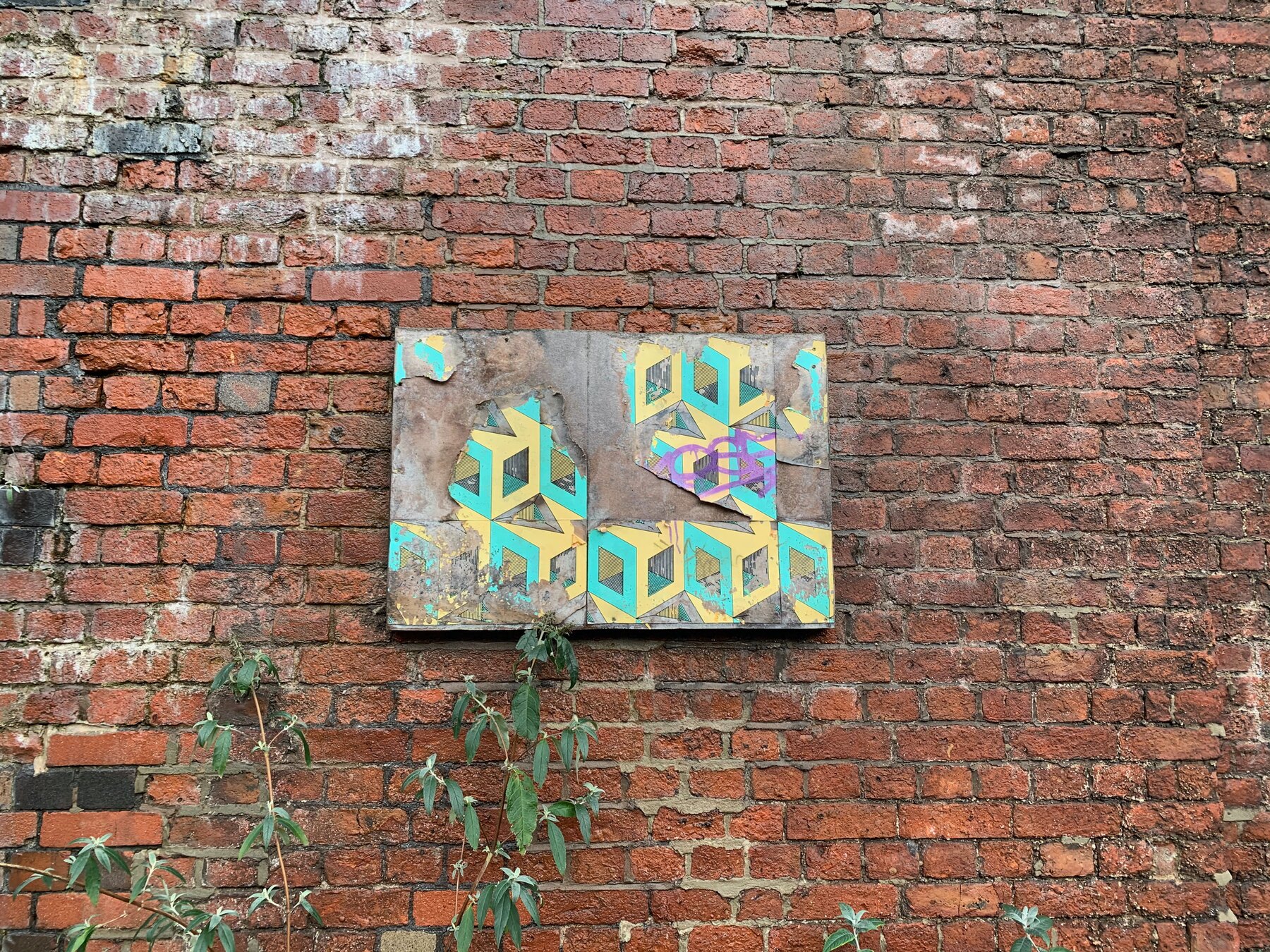 A weathered wallpaper board from the 2016 campaign still on a brick wall in 2021