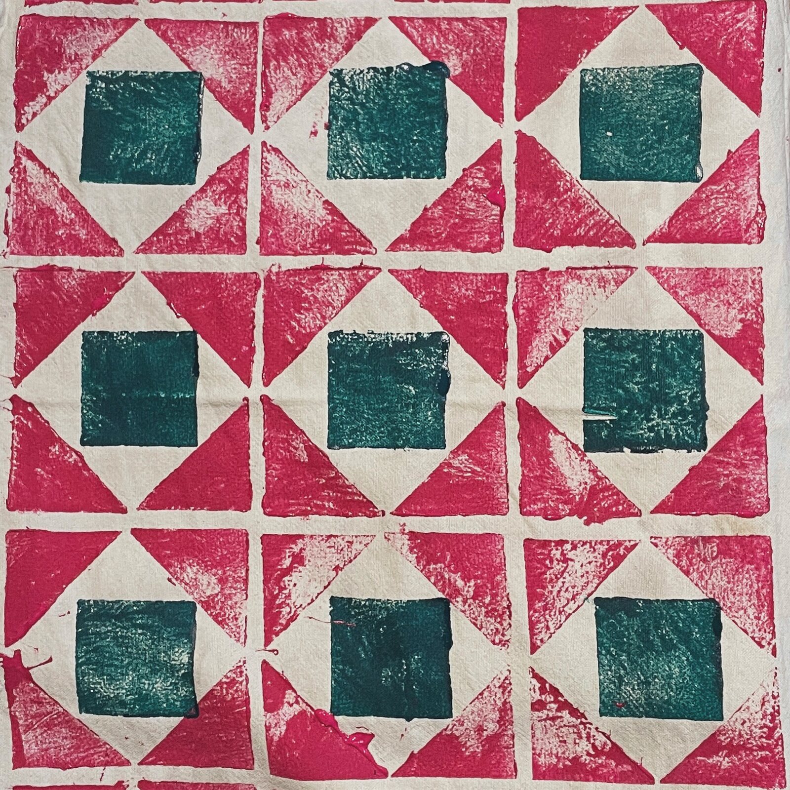A finished block print, green squares on a pink ground.