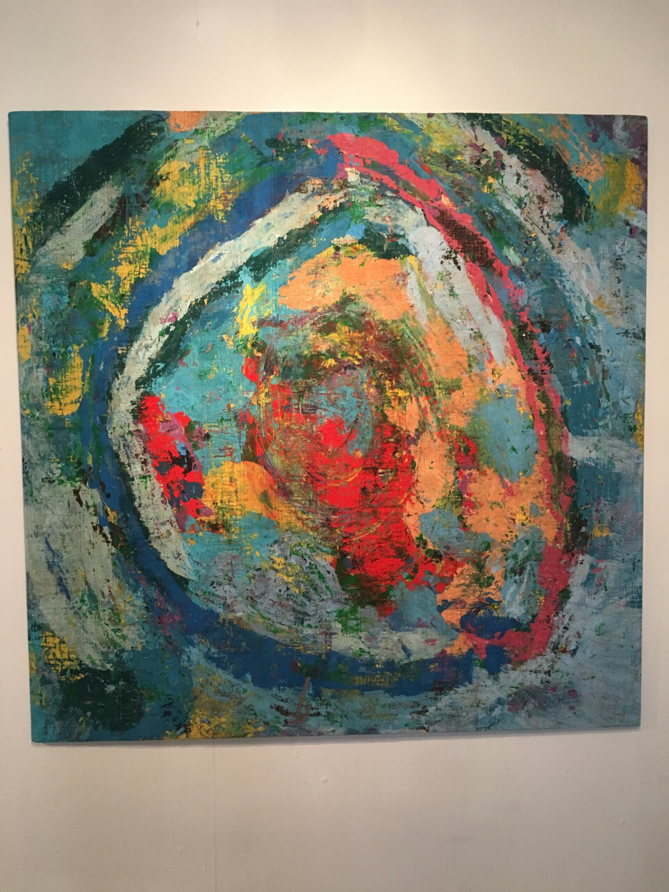 Close view of one of the paintings, dense layered brushwork in pink, green and black