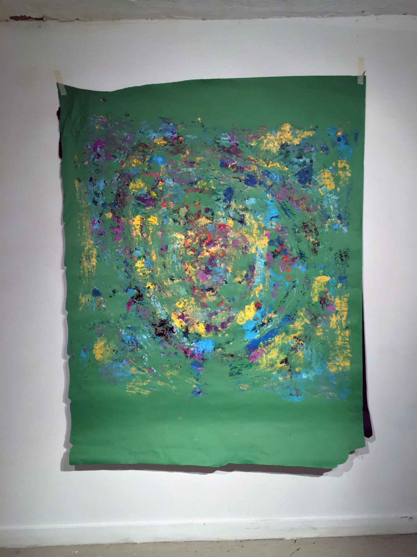 A rubbing taken onto green paper, showing the circular gesture transferred from a painting