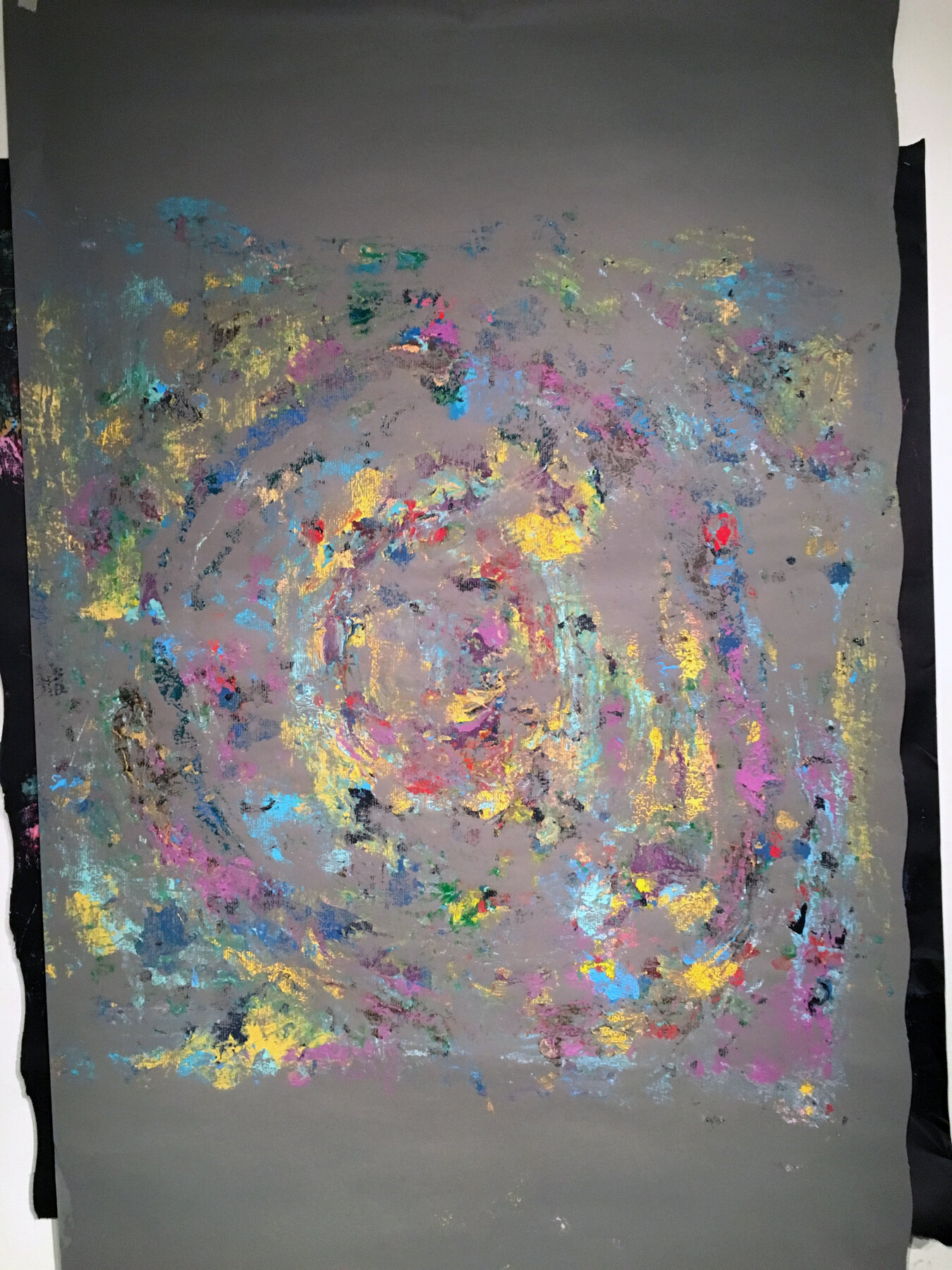 A rubbing taken onto grey paper, showing the circular gesture transferred from a painting
