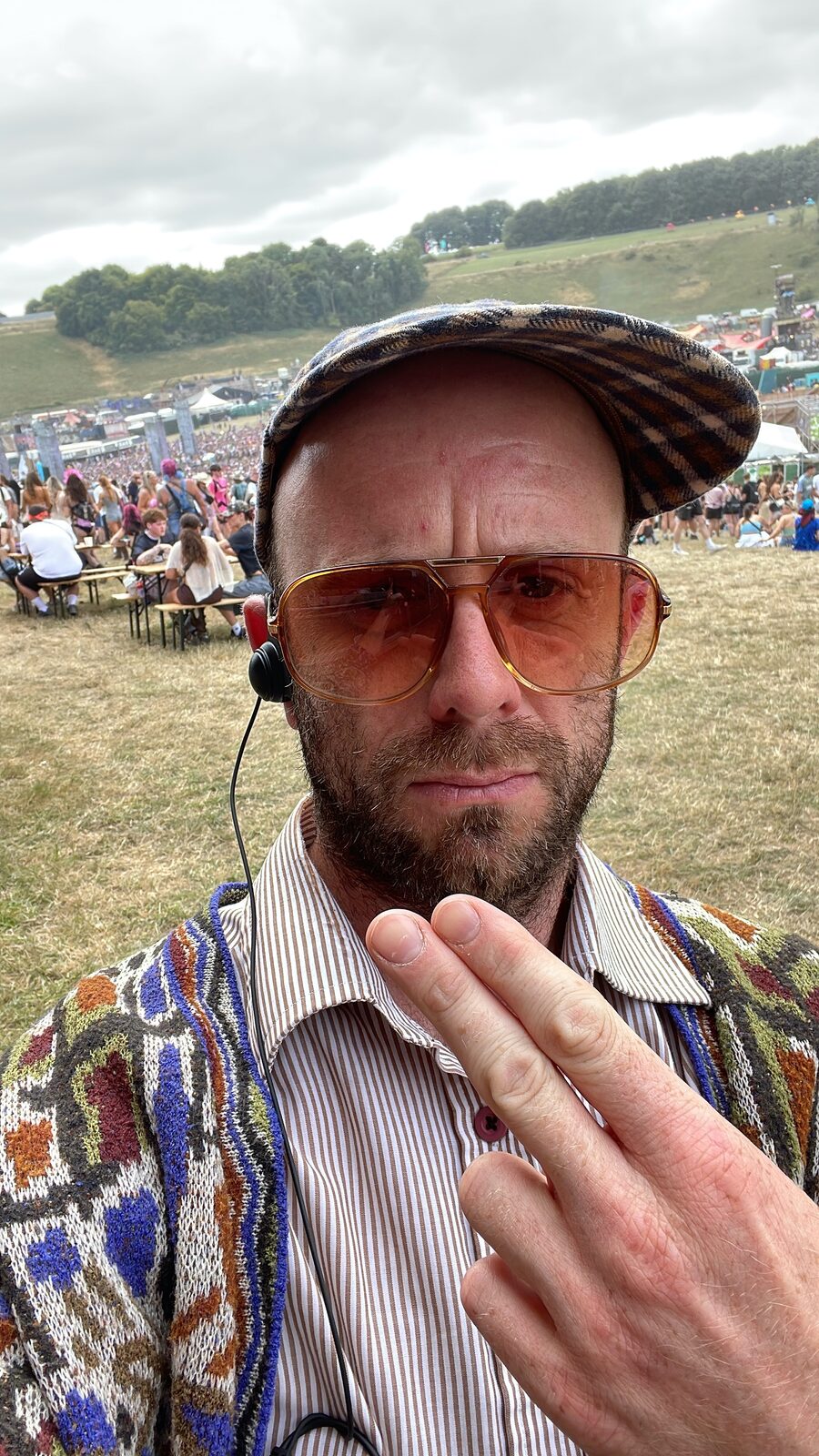Coordinating the photography team on site at Boomtown, headset on, crowd behind.