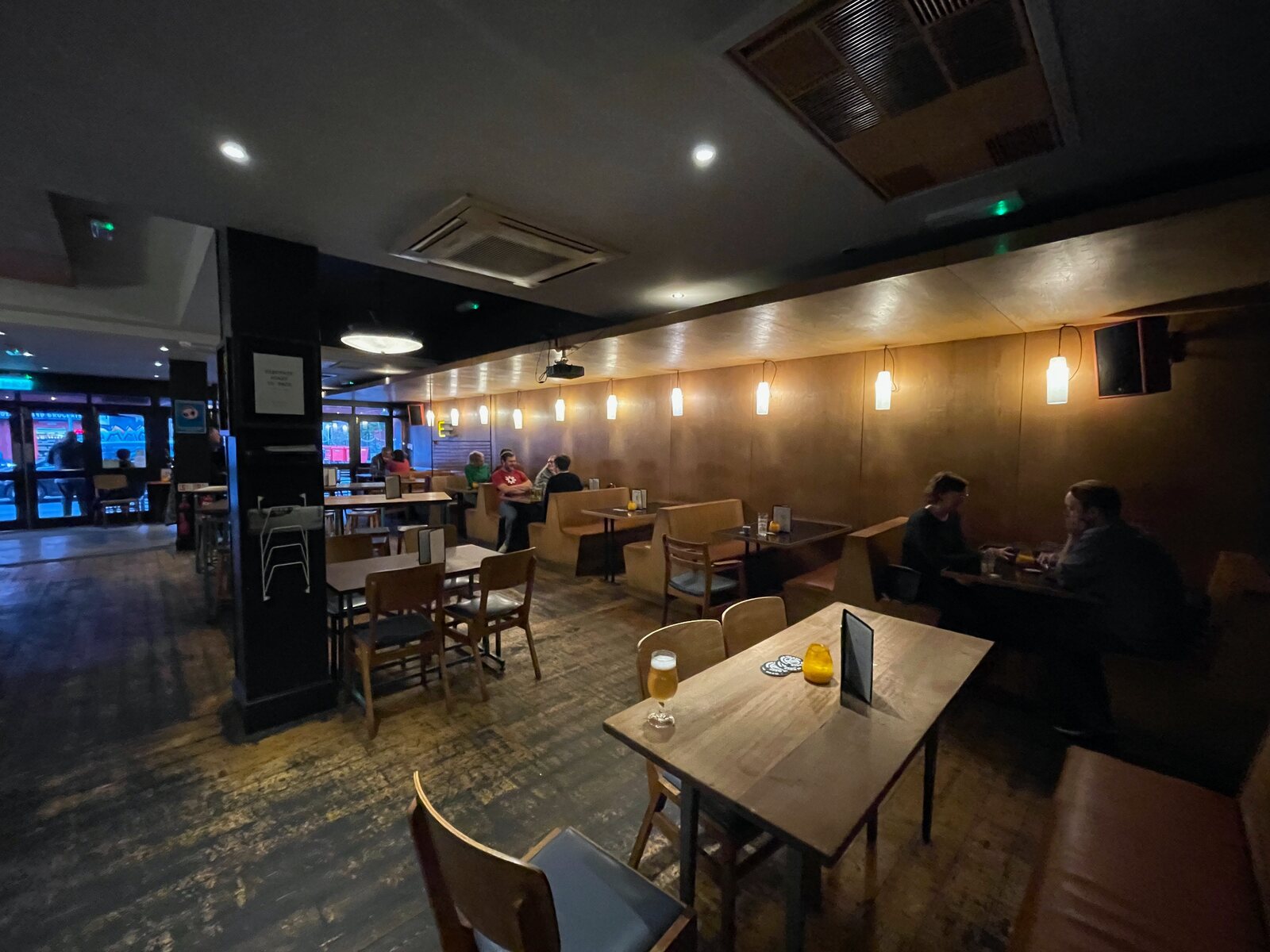 The long room at Electrik, tables and art on the walls.