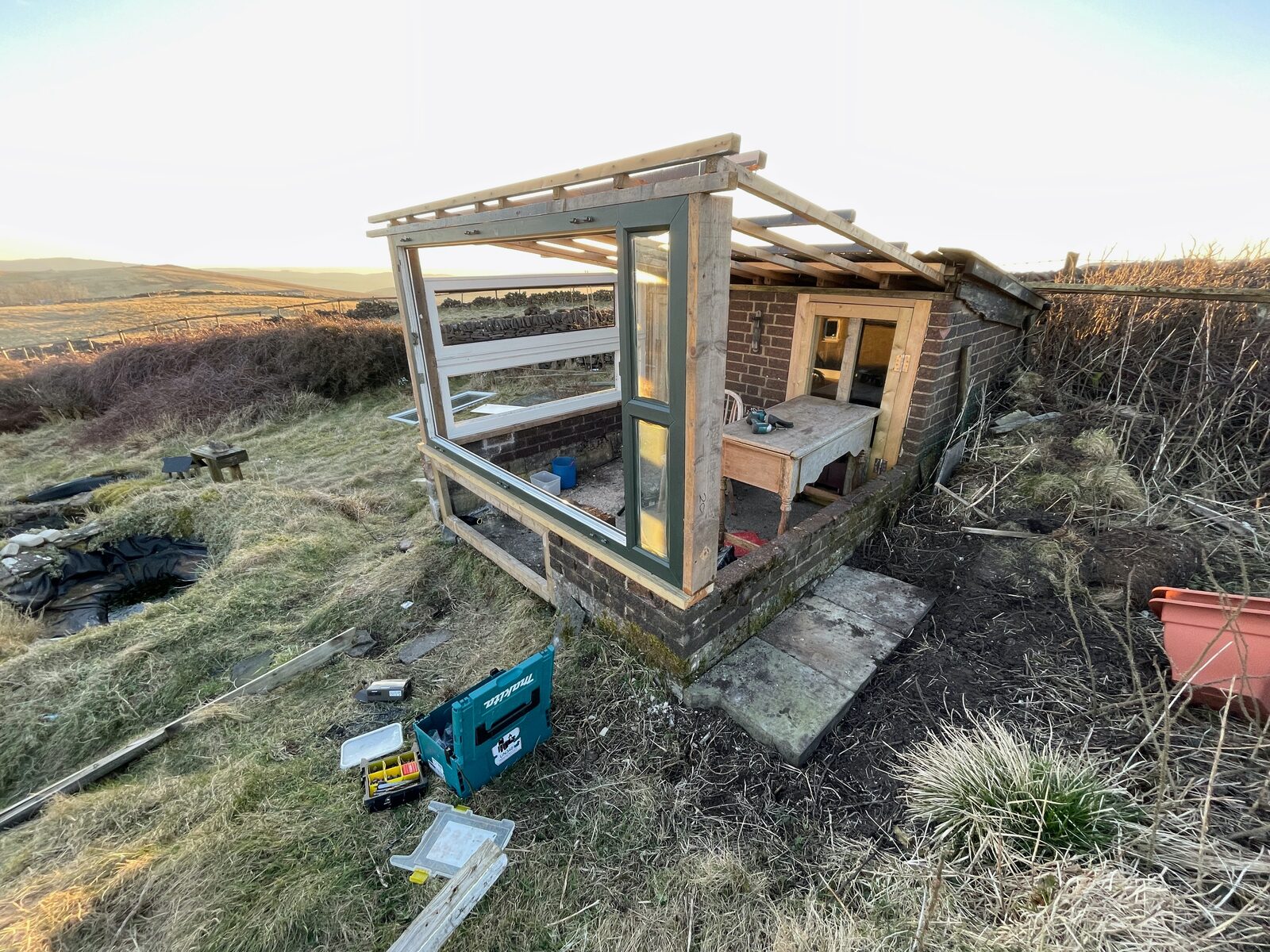 The recycled-window greenhouse taking shape on the moor.