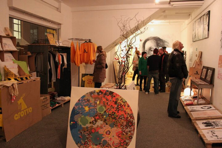 Inside Grotto, the pop-up shop, with branded t-shirts, artwork and visitors at an opening night