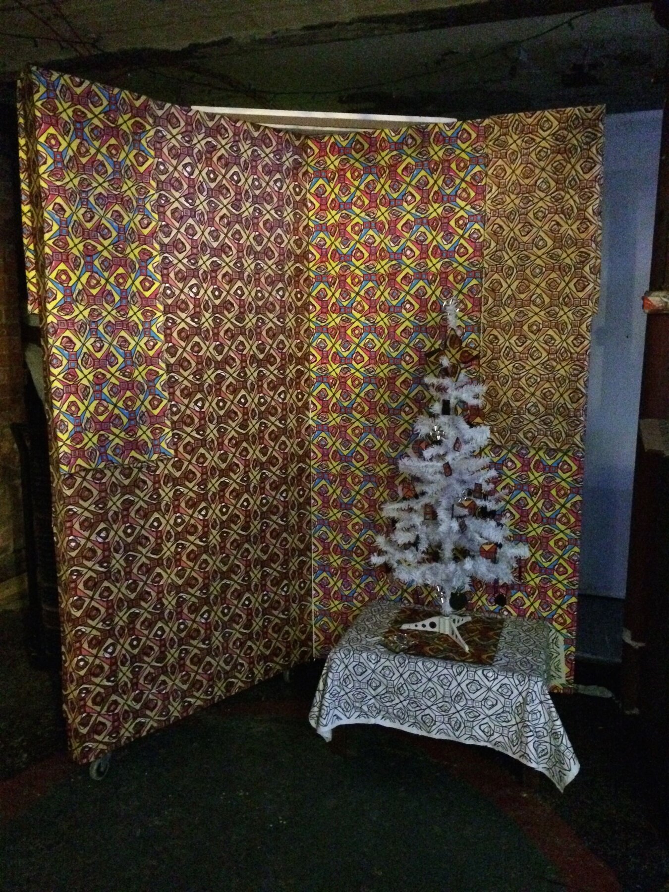 The Christmas at the Mill booth wrapped in the pattern, with a white tree in front