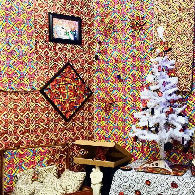 A corner of the booth with framed pattern pieces and the white tree