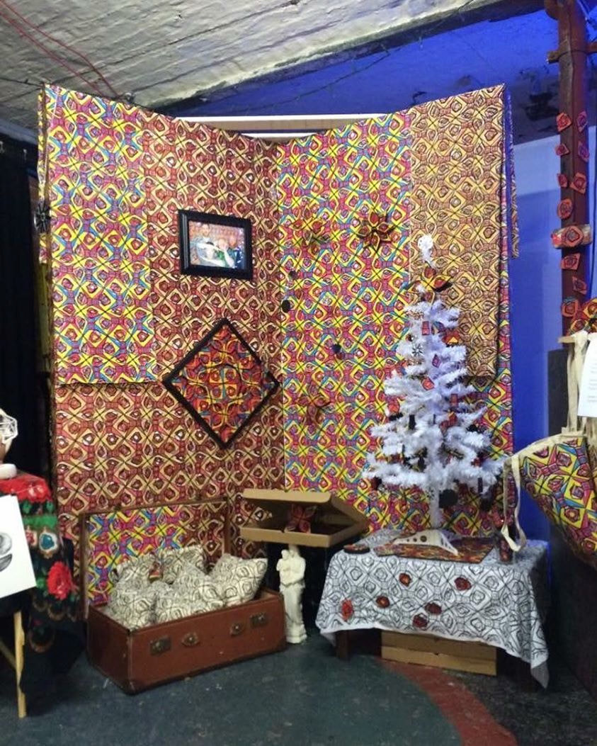 The full Christmas at the Mill booth, wallpaper, framed pieces, tree and product boxes