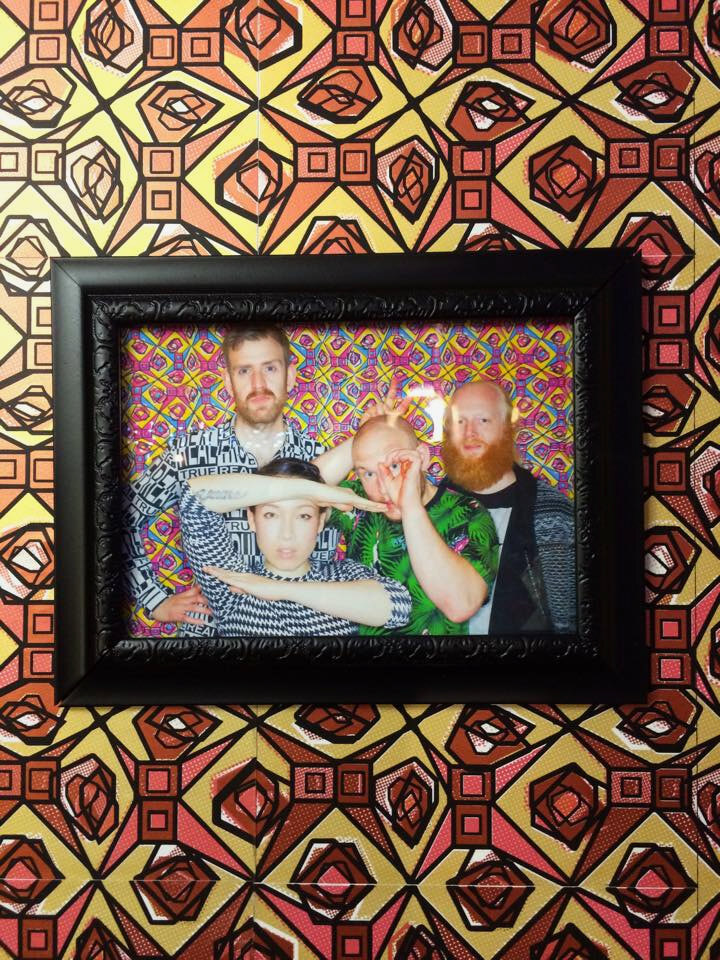 The finished Little Dragon photograph framed and hung on the pattern wallpaper