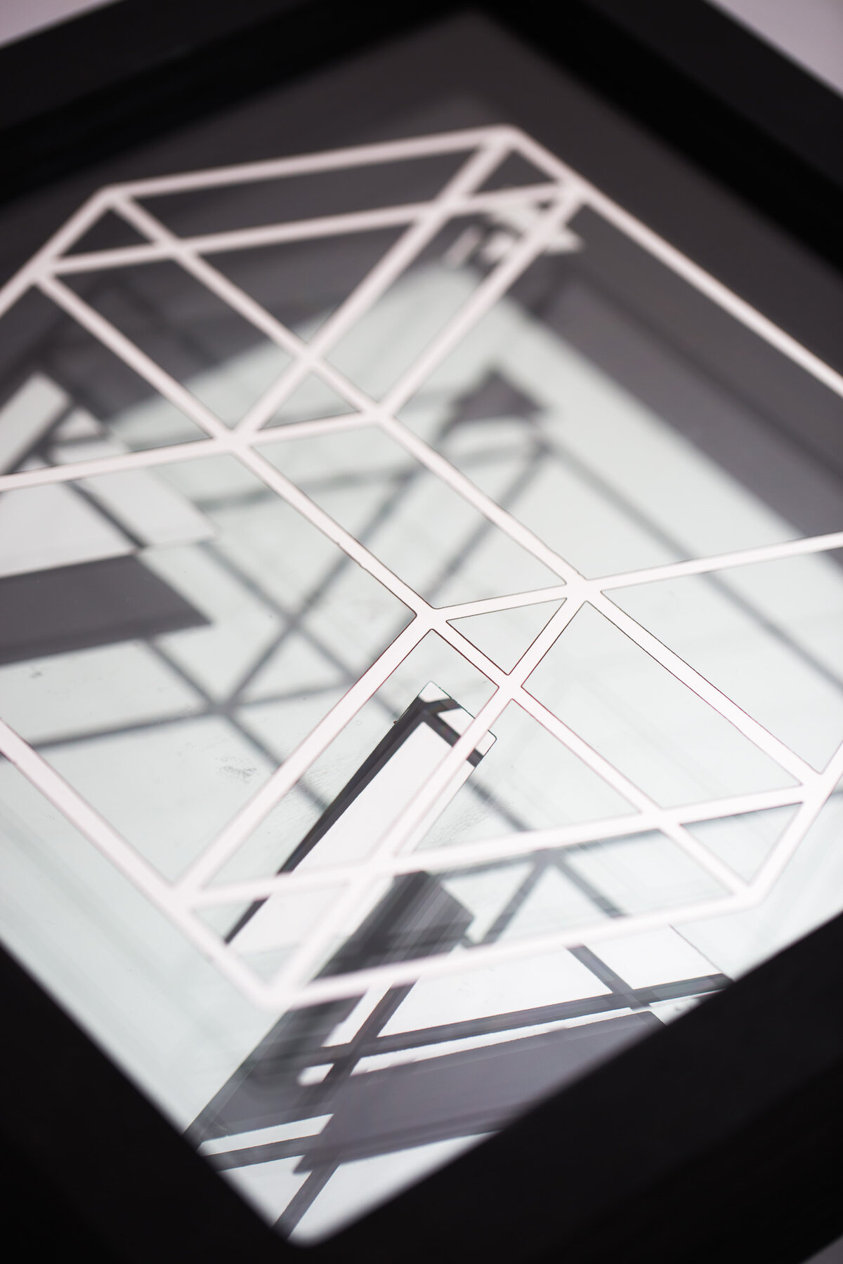 A framed mirror with a laser-etched and chemically eroded angular pattern