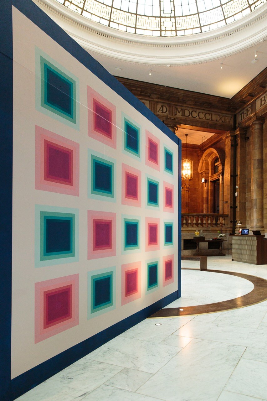 Third face of the acrylic mirror installation, a concentric squares pattern beneath the domed reception ceiling