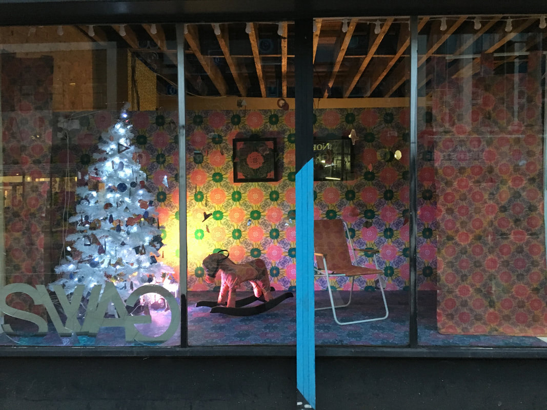 The SWAG Christmas shop window at night, a lit white tree, custom rocking horse and custom wallpaper