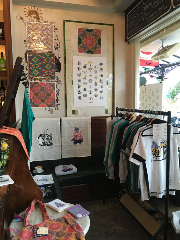Screen printed textiles, tote bags and clothing for sale inside the shop