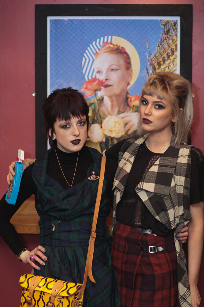 Costume competition entrants posing in front of the exhibited prints