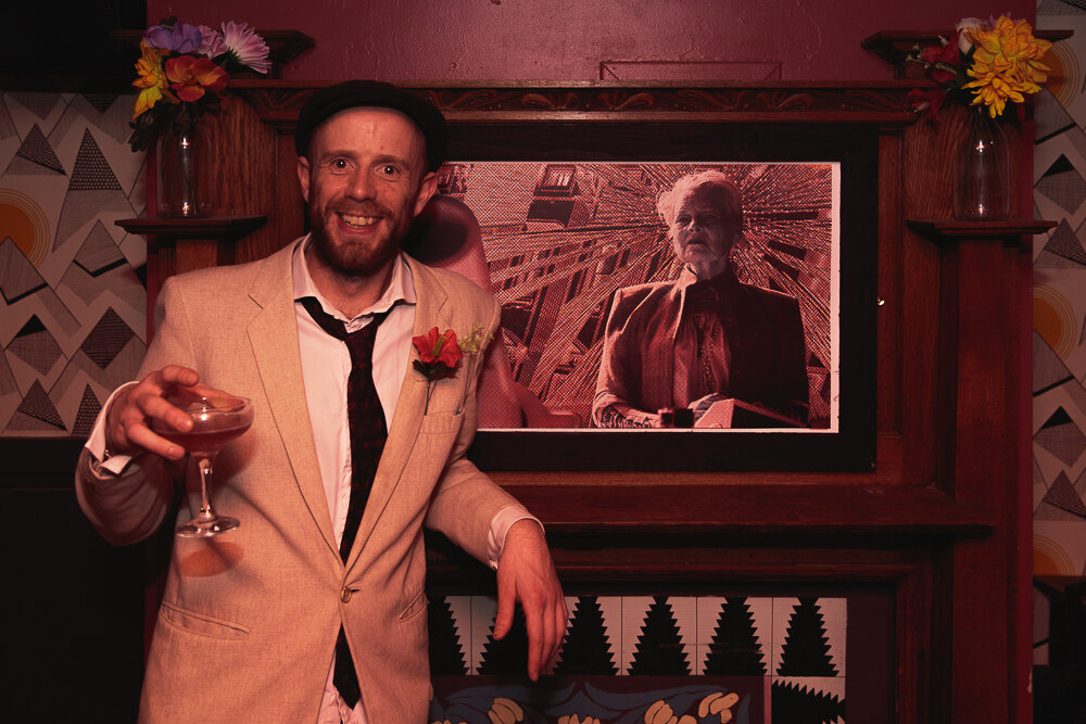 Guest photographed beside the Cannon Portrait print above the bar