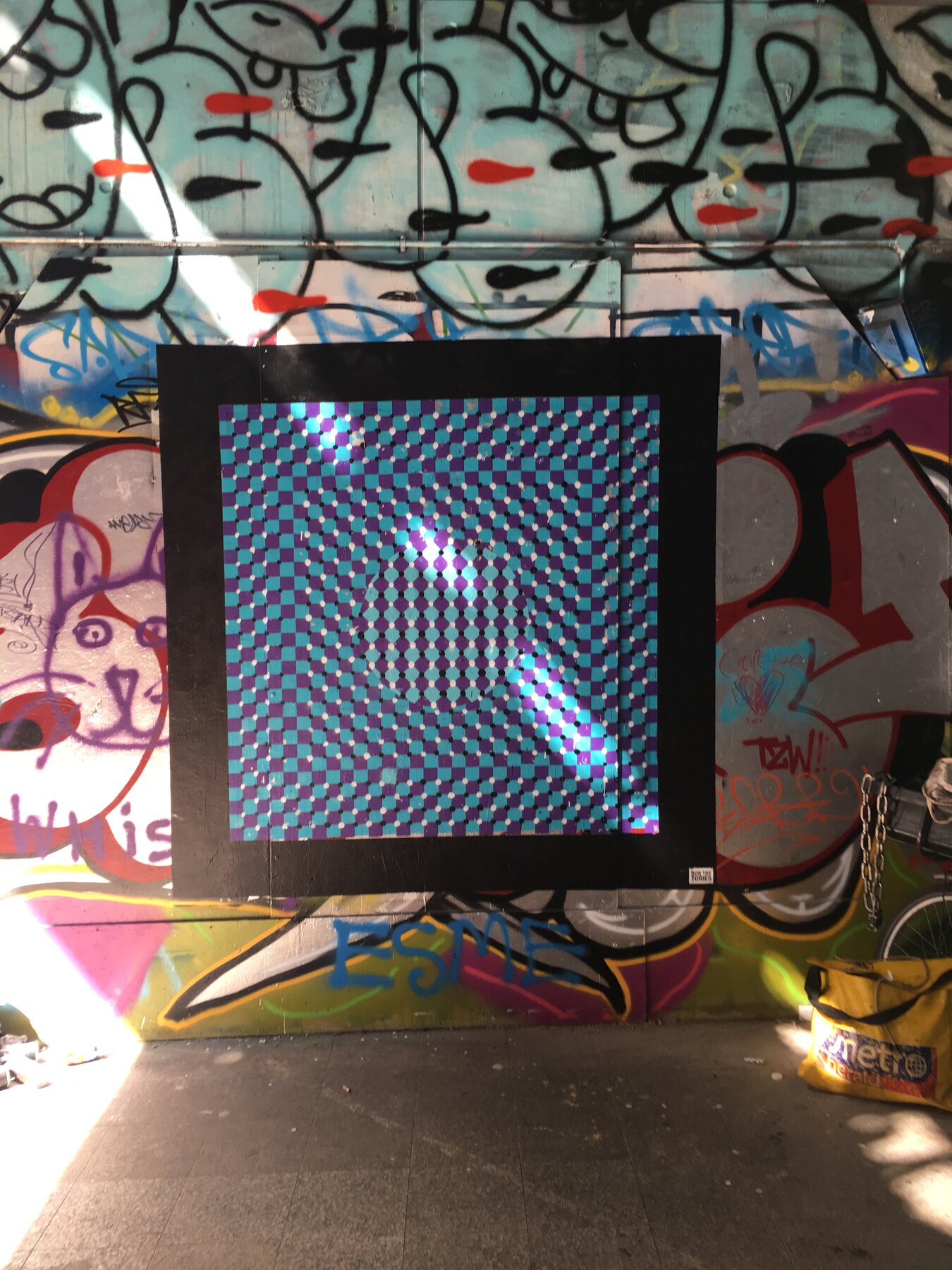 The op-art mural surrounded by other artists illustrative work at the Waterloo Paint Jam