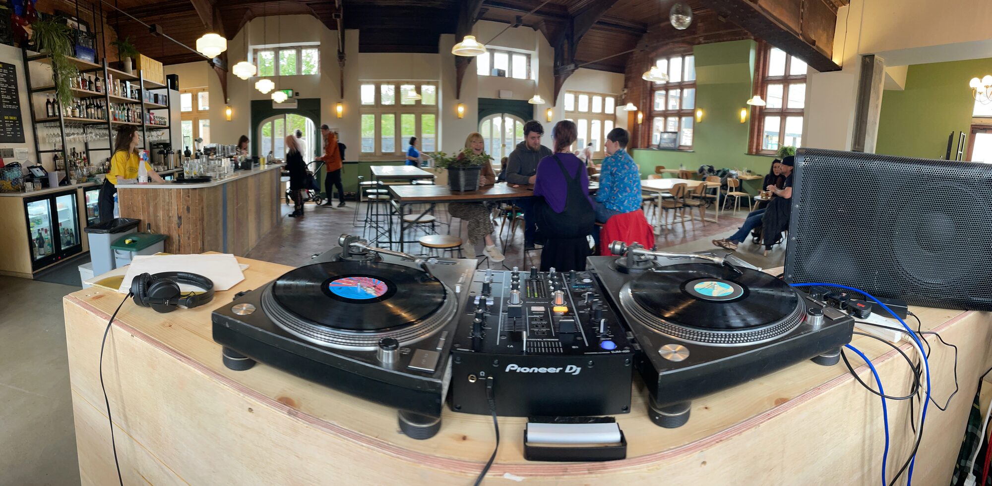 Two turntables and a mixer set up on a plywood counter in the main room at Station South